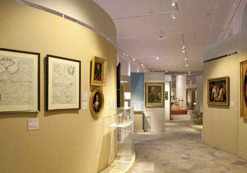 Kolorowe zdjęcie przedstawia sale ekspozycyjne. Na ścianach wiszą dzieła sztuki.