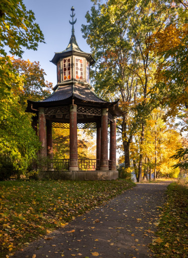 Kolorowe zdjęcie współczesne ptzedstawia budowlę w stylu chińskim w parku. Jest to altana chińska.
