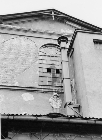 Zbliżenie na fragment budynku. Pod oknem znajduję się płaskorzeźba z herbem Pilawa.